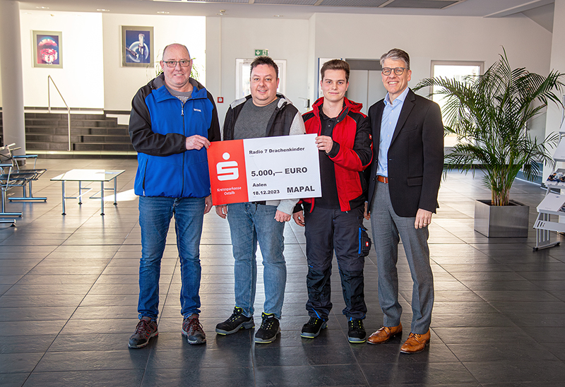Four men with a symbolic cheque in their hands